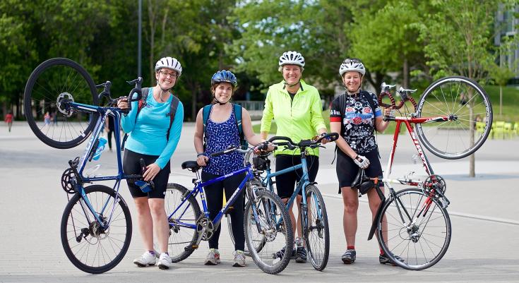 Four people holding up bikes as part of Go By Bike Week.