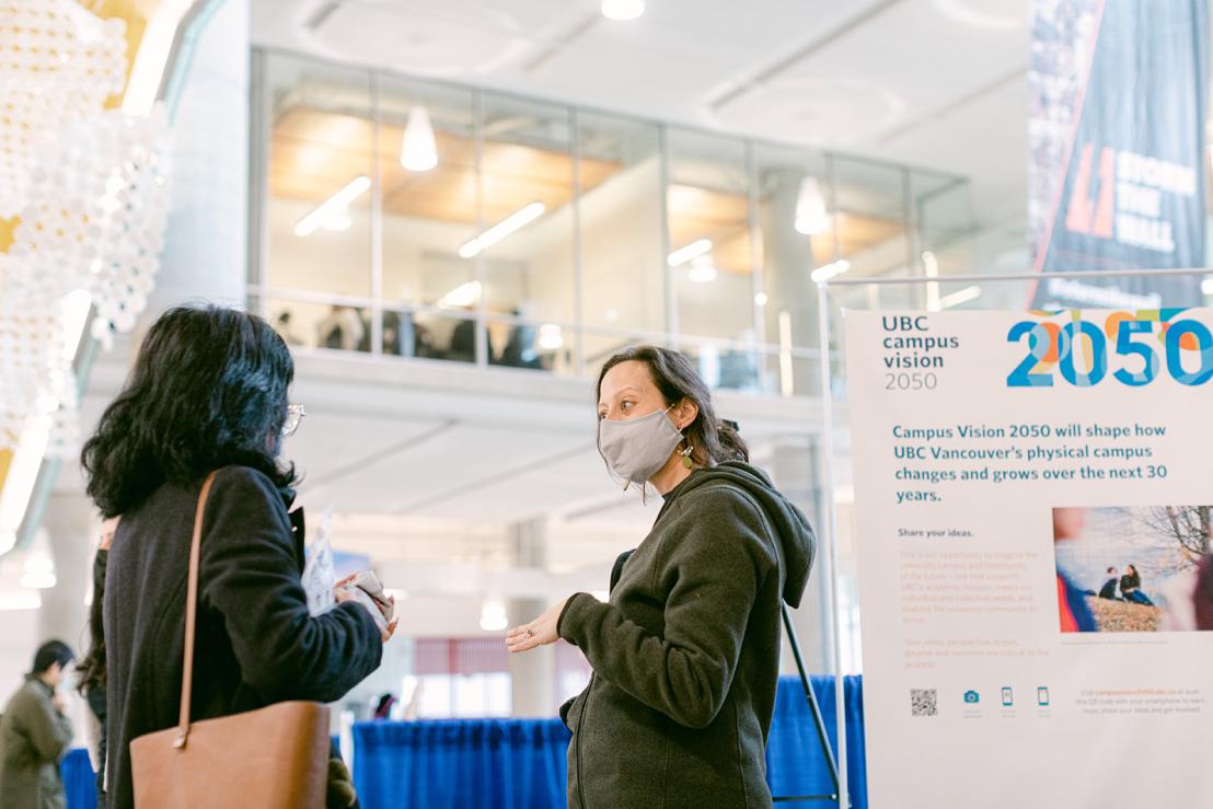 Image of a staff member talking with a member of the public about Campus Vision 2050