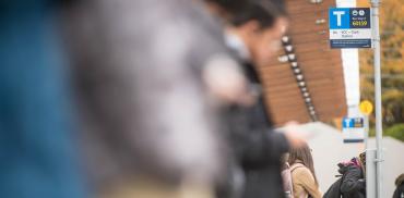 People wait for a bus at UBC bus exchange