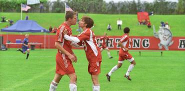 Mob=vie still from She's the Man with Amanda Bynes and Channing Tatum who wear red soccer uniforms and are on the field at UBC Thunderbird Stadium